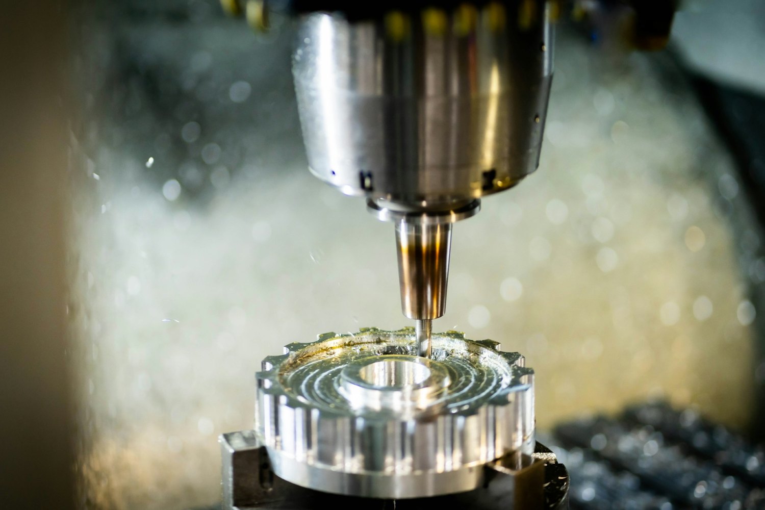 A machined metal component being cut on a CNC mill, illustrating precision machining at Glass Components, Inc.