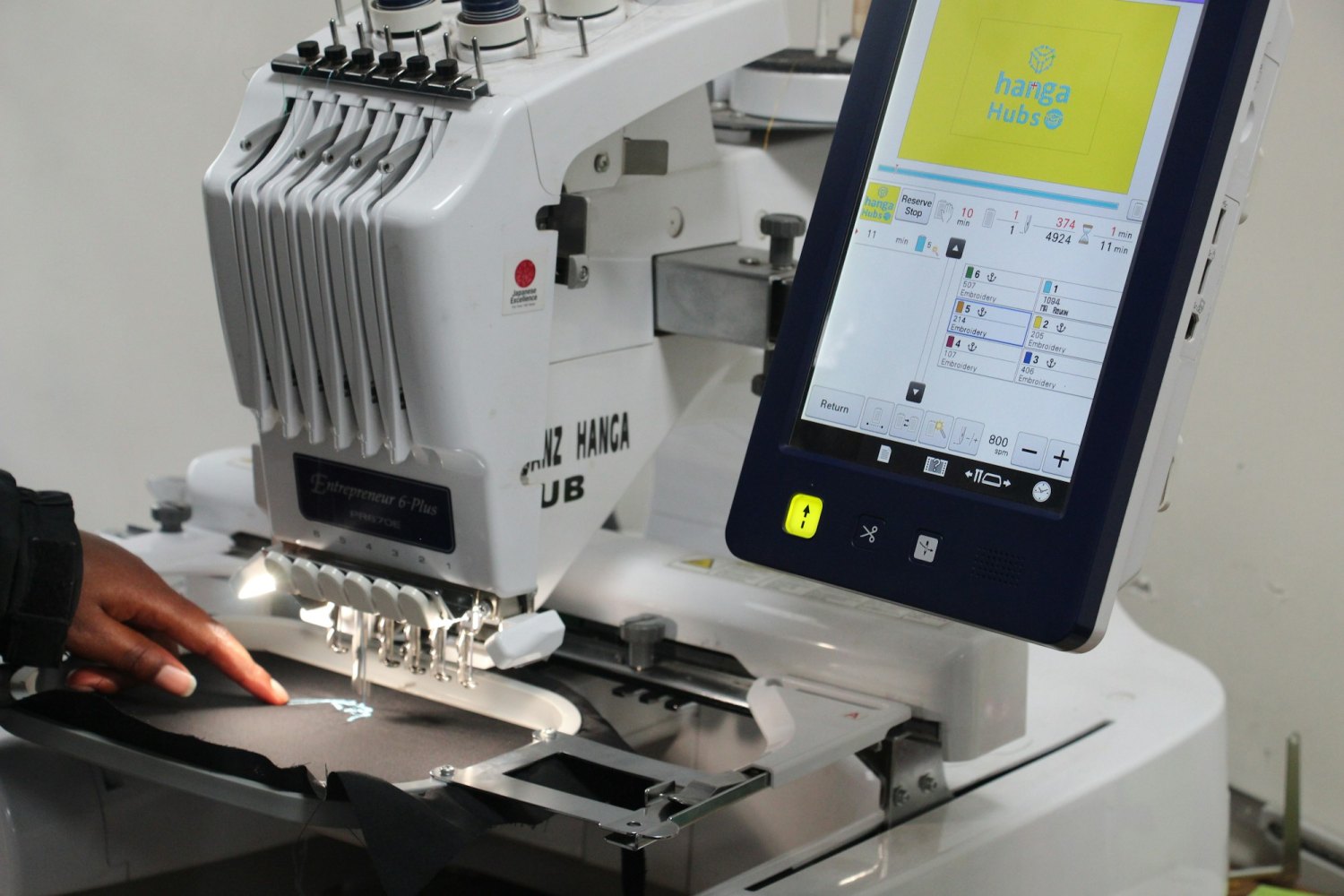A multi-head embroidery machine in operation, illustrating HydroJet's in-house custom apparel and embroidery