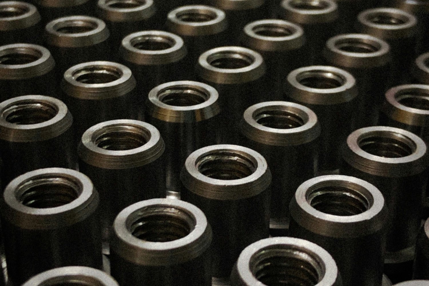 A batch of finished machined metal components, illustrating glass bottle forming machine parts